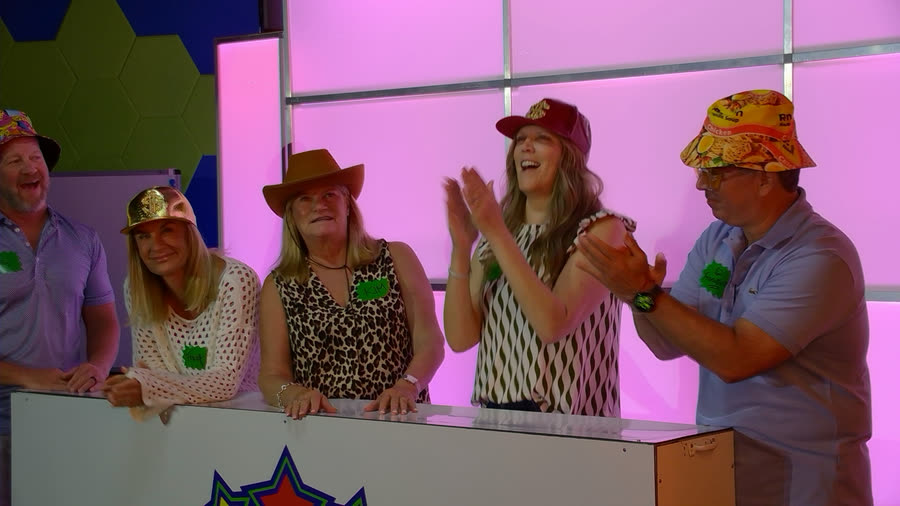 A team applauding at their podium in cowboy and bucket hats