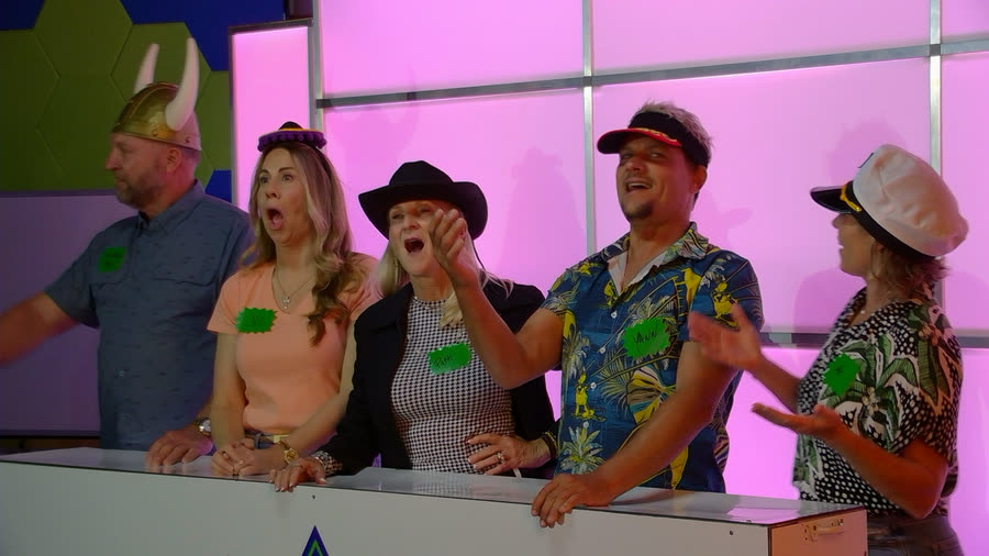 A team reacting at their podium in novelty hats