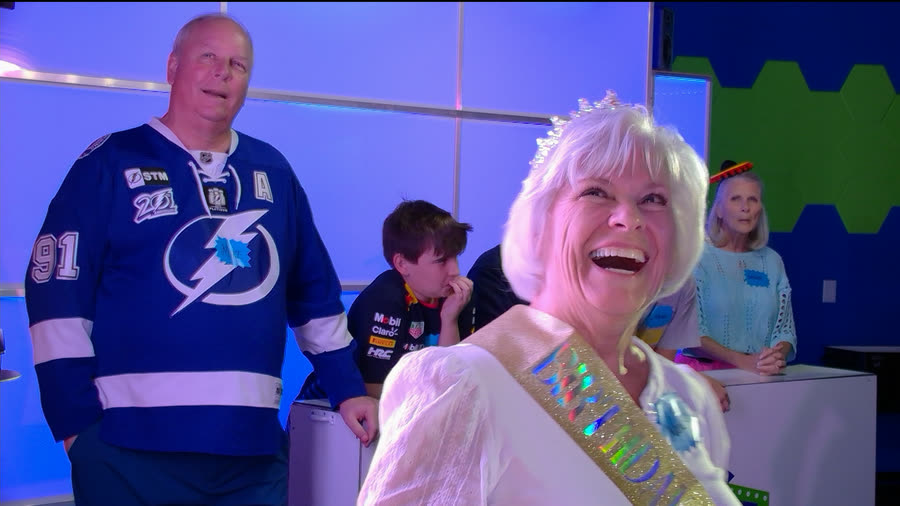 A guest wearing a birthday sash laughing during a round