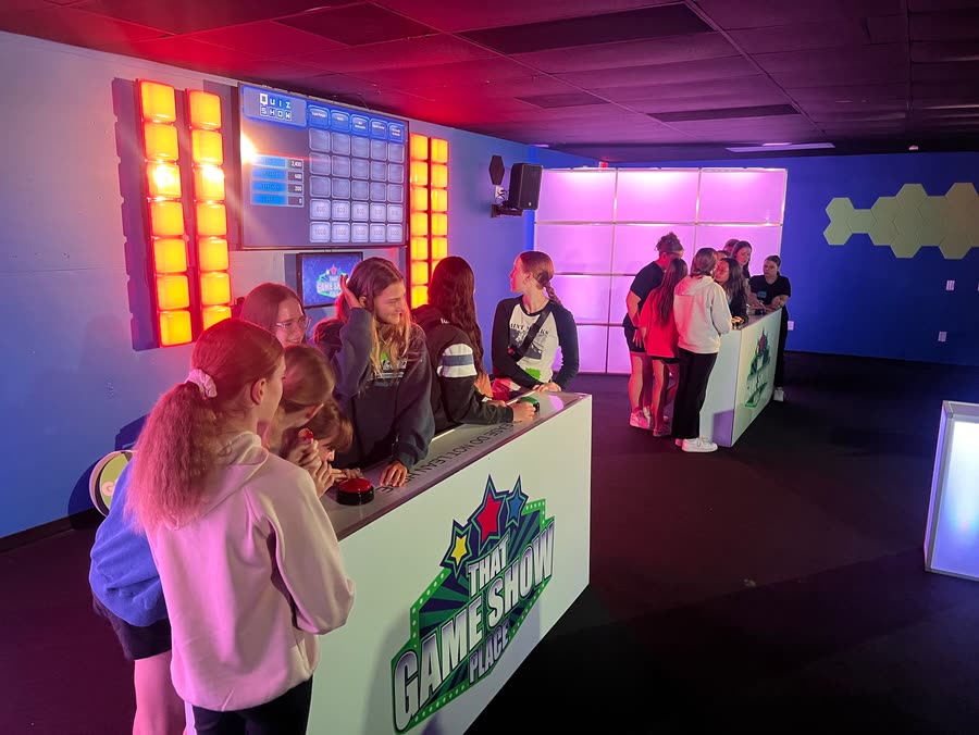 A school group crowded around the podium buzzers