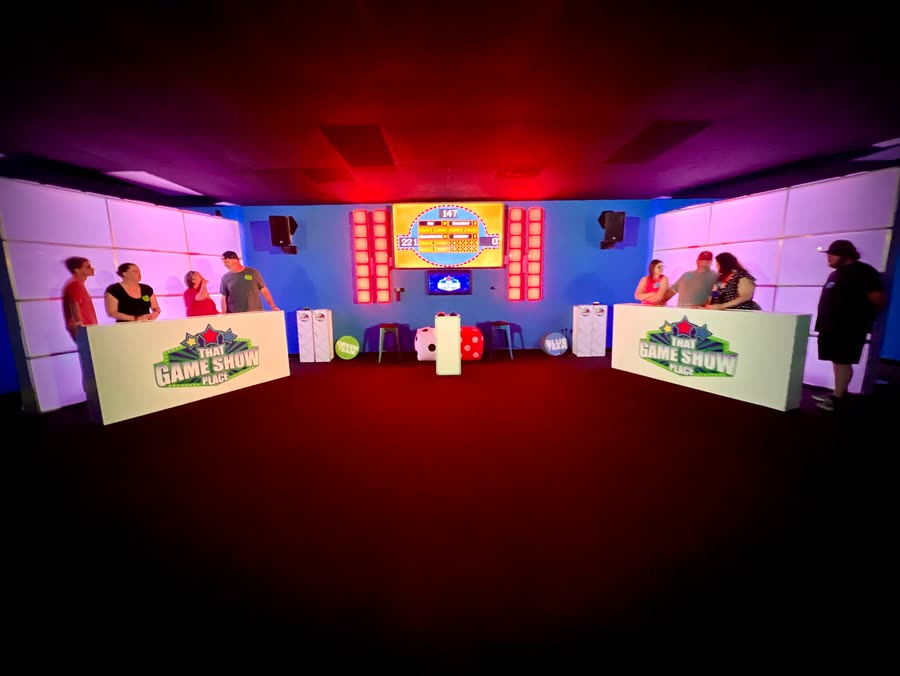 The studio lit red, both team podiums facing the scoreboard