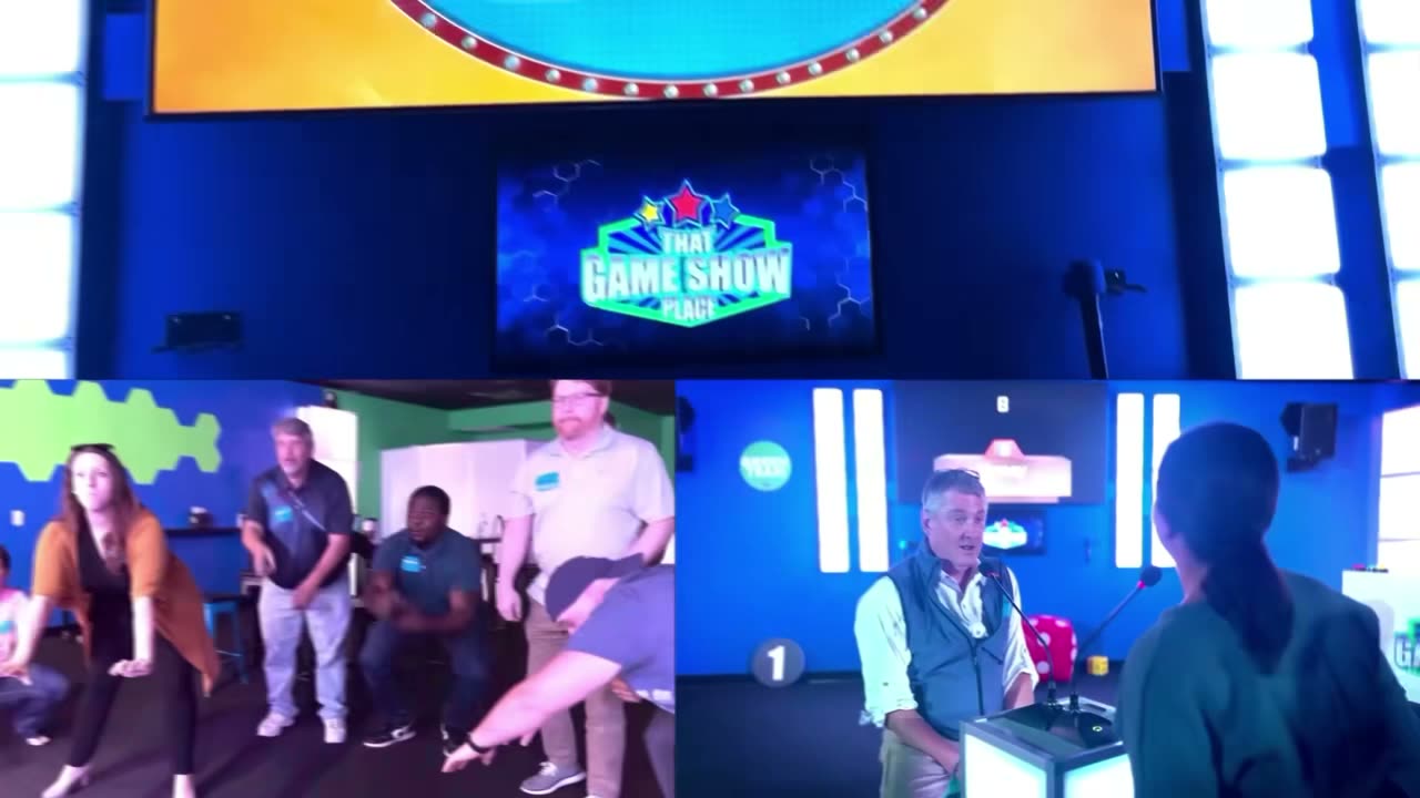 Players at the podiums mid-round, the studio lit up behind them